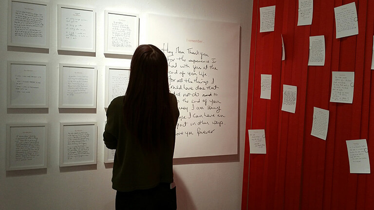 A lady is looking at the research work on the wall at the workshop